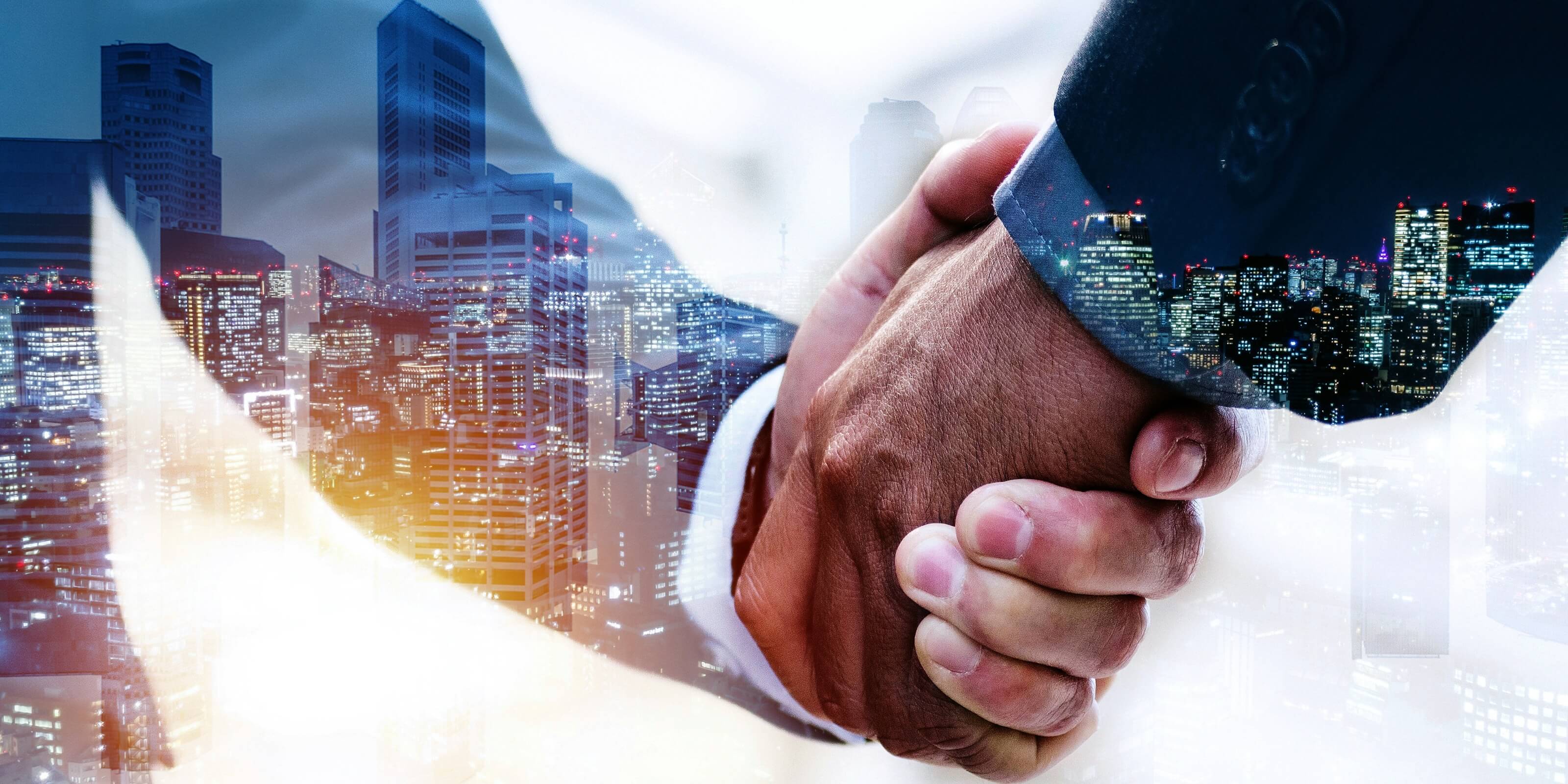 Two people shaking hands with a city skyline in the background